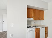 Thumbnail 11 of 13 - A kitchen with white appliances and wooden cabinets.