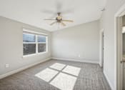 Thumbnail 16 of 27 - A room with a ceiling fan and a window with blinds.