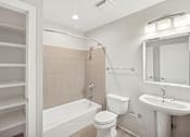 Thumbnail 9 of 13 - A white bathroom with a toilet, sink, and bathtub.