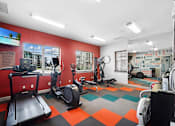 Thumbnail 27 of 32 - A gym with a treadmill, elliptical trainer, and other exercise equipment.