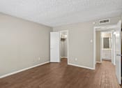 Thumbnail 2 of 14 - A room with a white door and a white cabinet with a mirror above it.
