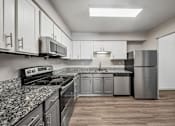 Thumbnail 1 of 35 - A kitchen with granite countertops and stainless steel appliances.