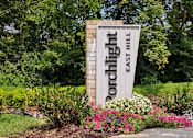 Thumbnail 1 of 149 - A sign for Porchlight East Hill surrounded by flowers.
