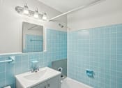 Thumbnail 7 of 13 - A bathroom with blue tiles and a white sink.