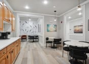 Thumbnail 11 of 25 - a dining room with a round table and chairs and a kitchen with a sink