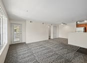 Thumbnail 16 of 25 - A large, empty room with a grey carpet and white walls.