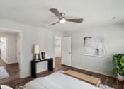 Thumbnail 6 of 25 - a bedroom with a large bed and a ceiling fan