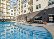 Thumbnail 24 of 39 - A swimming pool in front of apartment buildings.