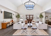 Thumbnail 19 of 26 - A clubhouse with a large rug and a chandelier.