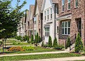Thumbnail 138 of 149 - A row of houses with a tree in the foreground.