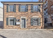 Thumbnail 1 of 15 - A brick building with a sign on the front door.