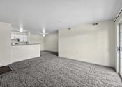 Thumbnail 13 of 25 - A large, empty room with a carpeted floor and white walls.
