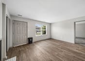 Thumbnail 35 of 35 - A room with a wooden floor and a door.