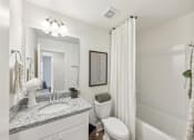 Thumbnail 23 of 25 - a white bathroom with a shower and a toilet and a sink