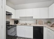Thumbnail 3 of 25 - an empty kitchen with white cabinets and black appliances