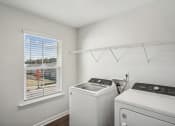 Thumbnail 23 of 25 - a white laundry room with a window and a white washer and dryer