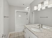 Thumbnail 22 of 27 - A white bathroom with a walk-in shower and double sinks.