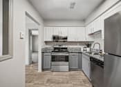 Thumbnail 34 of 35 - A modern kitchen with stainless steel appliances and white cabinets.