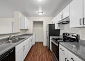 Thumbnail 17 of 25 - A kitchen with black appliances and white cabinets.