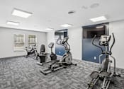 Thumbnail 10 of 35 - A gym with a variety of exercise equipment including treadmills, stationary bikes, and elliptical machines.