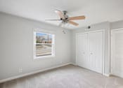 Thumbnail 8 of 11 - A room with a ceiling fan and a window showing an outdoor view.