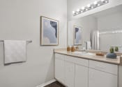 Thumbnail 7 of 25 - a bathroom with a sink and mirror and a towel rack