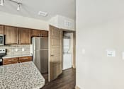 Thumbnail 39 of 39 - A kitchen with a refrigerator, oven, and microwave.