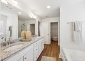 Thumbnail 17 of 25 - a white bathroom with two sinks and a mirror