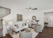 Thumbnail 14 of 25 - a living room with couches and chairs and a ceiling fan