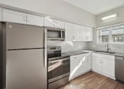 Thumbnail 3 of 27 - A modern kitchen with stainless steel appliances and white cabinets.