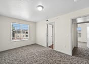 Thumbnail 22 of 25 - A room with a carpeted floor and a window showing a building outside.