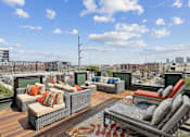 Thumbnail 46 of 66 - A patio with couches and a rug on a wooden deck.