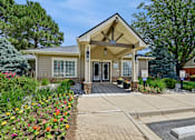 Thumbnail 5 of 25 - A building with a front porch and a small garden in front.