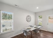 Thumbnail 16 of 25 - a dining room with a table and chairs and a clock on the wall