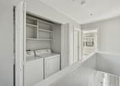Thumbnail 24 of 27 - A white laundry room with a washer and dryer.
