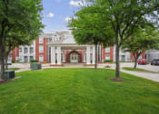 Thumbnail 24 of 25 - a large building with a lawn and trees in front of it