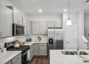 Thumbnail 13 of 25 - a white kitchen with stainless steel appliances and marble counter tops