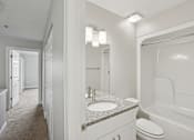 Thumbnail 20 of 27 - A white bathroom with a sink, toilet, and bathtub.