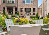 Thumbnail 149 of 149 - A patio with chairs and a table in front of a building.