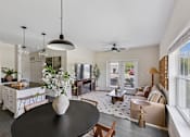 Thumbnail 10 of 26 - A modern kitchen with a black table and a ceiling fan in the living room.