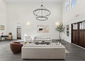 Thumbnail 35 of 36 - A living room with a grey sofa and a wooden floor.