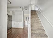 Thumbnail 5 of 27 - A staircase with a beige carpeted runner leads up to a white door.