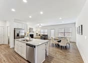 Thumbnail 6 of 26 - a kitchen and living room with a table and chairs