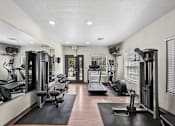 Thumbnail 8 of 25 - A gym with a variety of equipment including treadmills, weights, and exercise machines.