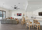 Thumbnail 36 of 36 - A modern living room with a grey couch and wooden chairs.
