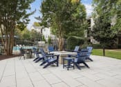 Thumbnail 36 of 47 - an outdoor patio with blue chairs and tables and a pool