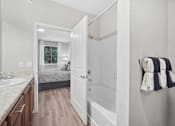 Thumbnail 7 of 32 - A bathroom with a white sink and a white tub.