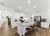 Thumbnail 3 of 26 - a white kitchen with a marble counter top and a stainless steel refrigerator