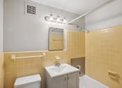 Thumbnail 13 of 13 - A bathroom with yellow tiles and a white toilet.