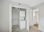 Thumbnail 9 of 11 - A white laundry room with a washer and dryer.